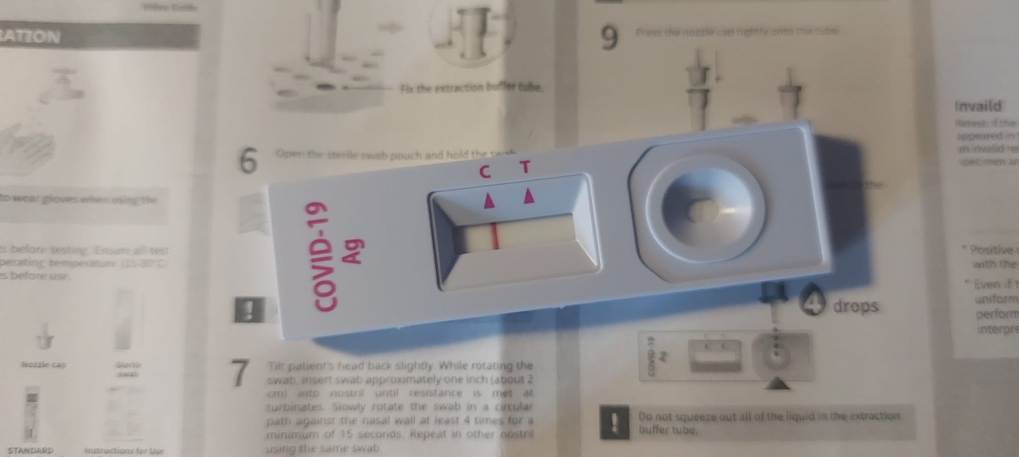 An image of a negative rapid Covid-19 test taken ontop of instructions for using the test